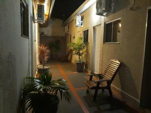 an empty courtyard with a chair and potted plants at Hotel Vintage in Assis