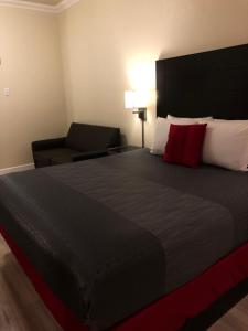 1 dormitorio con cama grande y almohada roja en Gateway Inn and Suites San Francisco SFO Airport, en San Bruno