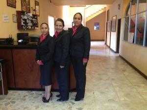 a group of three women in suits standing in a hallway at Hotel San Miguel in Morelia