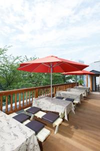 a row of tables and an umbrella on a deck at Day Nice Hotel Tokyo in Tokyo