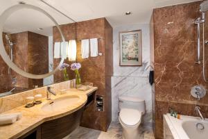 a bathroom with a sink and a toilet and a tub at The Kunlun Jing An in Shanghai +47 photos