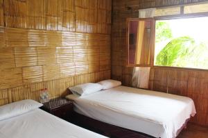 Duas camas num quarto com uma janela em El Refugio del Sol em Playas