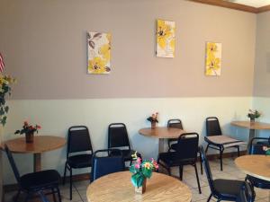 a room with tables and chairs with flowers on the wall at Spinning Wheel Inn in Branson