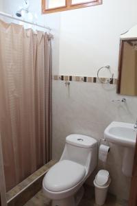 uma casa de banho com um WC, um lavatório e um chuveiro em El Refugio del Sol em Playas