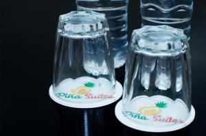 dos vasos vacíos sentados junto a una botella de agua en Piña Suites en Ormoc