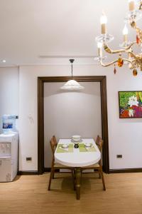 a dining room with a table and chairs and a chandelier at Hong Gia Tue Apartment in Hanoi