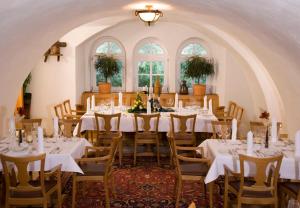 a large dining room with white tables and chairs at Waldhotel Nachtigall in Paderborn