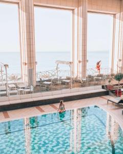 een vrouw in een zwembad op een cruiseschip bij Hyatt Regency Nice Palais de la Méditerranée in Nice