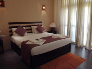 a bedroom with a large bed with two towels on it at Seacoast Sanctuary Beach Hotel in Hiriketiya