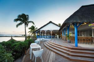 a restaurant on the beach with chairs and tables at Veranda Pointe Aux Biches Hotel & Spa in Trou aux Biches