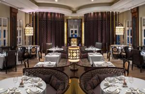 a dining room with tables and chairs and chandeliers at Capella Singapore in Singapore