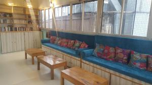 a blue couch in a library with pillows and tables at Baba Guest House in Varanasi
