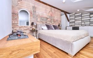 sypialnia z łóżkiem i ścianą z cegły w obiekcie Chodkiewicza 10 (A) - cozy studio by Homeprime w Krakowie