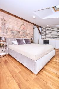 sypialnia z dużym łóżkiem i ceglaną ścianą w obiekcie Chodkiewicza 10 (A) - cozy studio by Homeprime w Krakowie