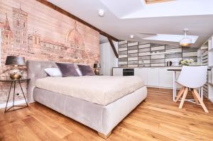 sypialnia z dużym łóżkiem i ceglaną ścianą w obiekcie Chodkiewicza 10 (A) - cozy studio by Homeprime w Krakowie