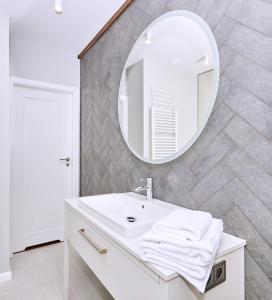 łazienka z białą umywalką i lustrem w obiekcie Chodkiewicza 10 (A) - cozy studio by Homeprime w Krakowie +9 zdjęć