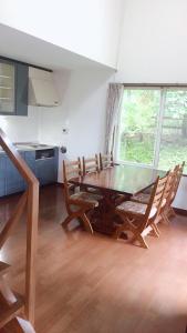 une salle à manger avec une table et des chaises en bois dans l'établissement Cottage Ginkai Fuji, à Yamanakako