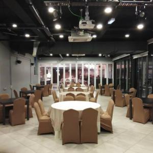 a room with a table and chairs and a room with tables at Amerin Hotel Johor Bahru in Johor Bahru