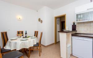 a kitchen and dining room with a table and chairs at Apartman Maledi in Baška