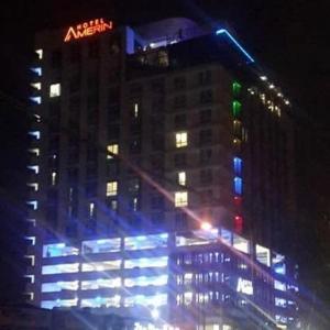 a tall building with blue and green lights on it at Amerin Hotel Johor Bahru in Johor Bahru