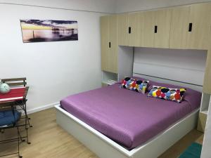 een slaapkamer met een paars bed en een bureau bij La Casetta del Corso in Ortona