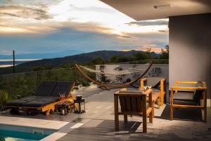 a patio with a pool and chairs and a view of the mountains at Luxury Villa Ena in Grižane