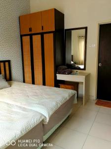 a bedroom with a bed and a dresser and a mirror at M.R Homestay Morib Gold Coast Resort in Banting