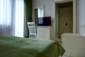a bedroom with a bed and a tv and a chair at Hotel Gorenje in Pristina