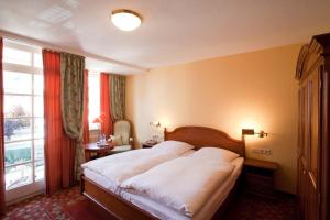 a bedroom with a large bed and a large window at Hotel Karpfen in Eberbach