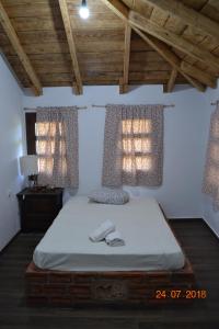 a bedroom with a bed and two windows with curtains at Mouson Melathron in Elafina