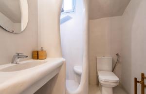 a white bathroom with a sink and a toilet at Plaka Suites in Plaka Milou