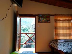 ein Schlafzimmer mit einem Fenster und einem Bett in einem Zimmer in der Unterkunft Termas El Pantanal in Papallacta