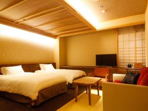 a hotel room with two beds and a tv at Minato Koyado Awajishima in Minamiawaji