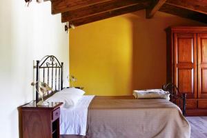 1 dormitorio con cama y pared amarilla en Borgo Patierno en Conca della Campania