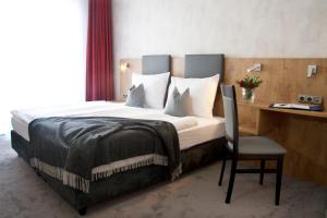 a bedroom with a bed with a desk and a chair at Boardinghouse Landshut in Landshut