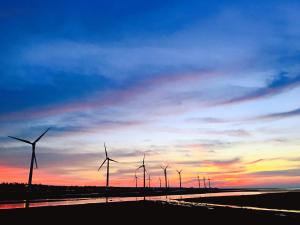 eine Gruppe von Windmühlen auf einem Feld bei Sonnenuntergang in der Unterkunft Chen The House in Qingshui