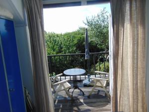 eine Terrasse mit einem Tisch und Stühlen auf dem Balkon in der Unterkunft villa Flore, studio's in Bergen aan Zee