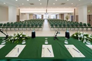 a conference room with chairs and a green table with speeches at Hotel Corallo in Riccione +142 photos