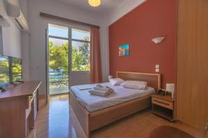 1 dormitorio con cama y ventana grande en Hotel Akti, en Loutraki