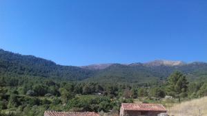 two houses in a valley with mountains in the background at Casas Valleiruelas in Las Cruceras