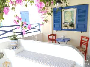 a porch with blue shutters and a bench at Villa Spyros Santorini in Perissa