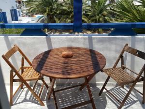 a wooden table and two chairs on a balcony at Villa Spyros Santorini in Perissa