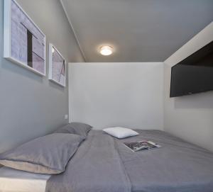 a bedroom with a bed with a tv on the wall at Suite Vogue City in Voghera