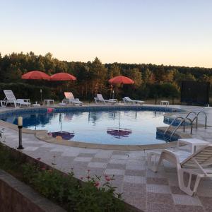 a large swimming pool with chairs and umbrellas at Dream Bay Apartments in Tsarevo +21 photos