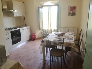 a kitchen and dining room with a table and chairs at B&B La Rondinella in Montecerboli