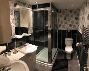 Un baño con ducha, inodoro y lavabo. en Empress Select Holiday Flats, en Blackpool 39 fotos más