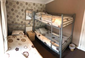 Un dormitorio con dos literas y un espejo. en Empress Select Holiday Flats, en Blackpool