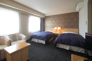 
A bed or beds in a room at Hotel Excel Okayama
