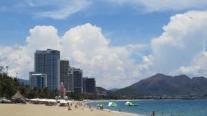 a group of people on a beach with buildings at Hotel Hồng Hạc nha trang in Nha Trang