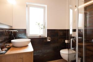 a bathroom with a sink and a toilet and a window at Hotel Schwaiger in Glonn